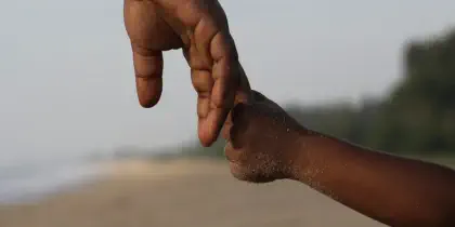 Closeup of the hands of an adult and child holding hands