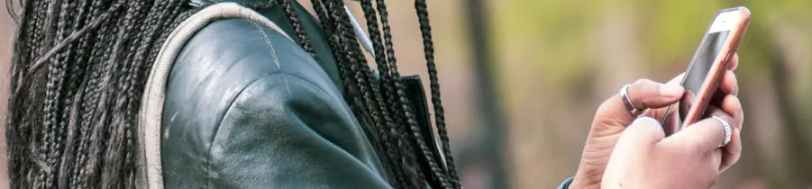 A young woman is looking at and using her mobile phone