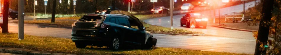 An SUV is sideways in the median with obvious damage to the front and back of the car
