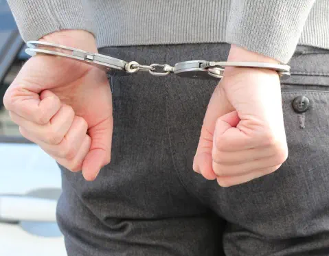 Closeup of a man's hands, handcuffed behind his back