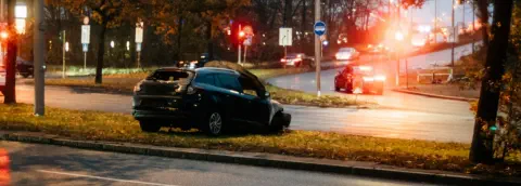 An SUV is sideways in the median with obvious damage to the front and back of the car